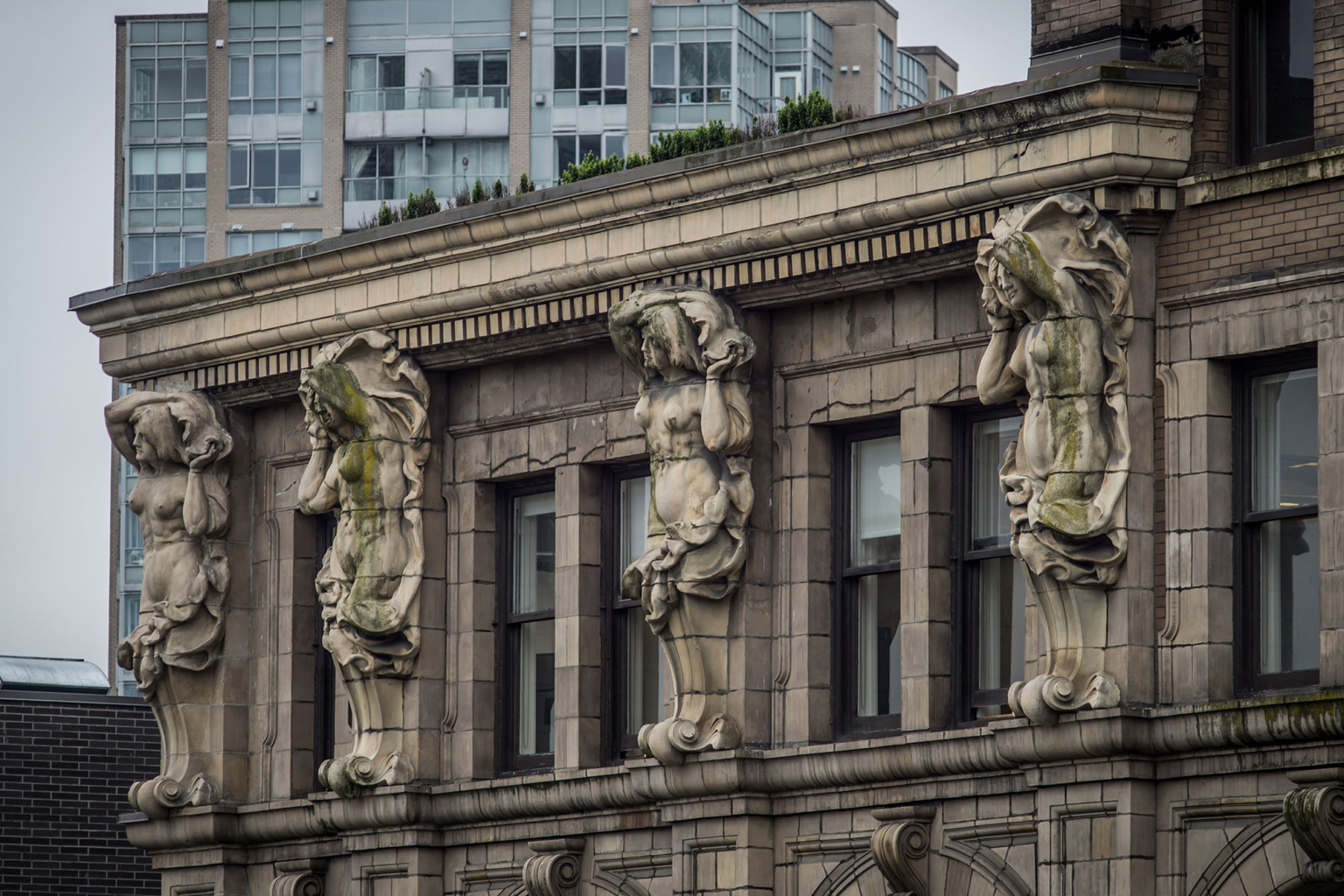 The Sun Tower in Vancouver with its iconic caryatids sculpted by Charles Marega, showcasing detailed architectural artistry.