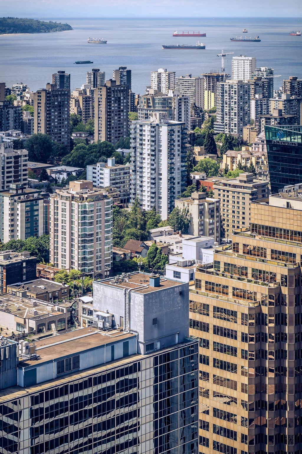 Aerial view of Vancouver's West End, showcasing high-rise apartments, heritage buildings, and English Bay in the background.