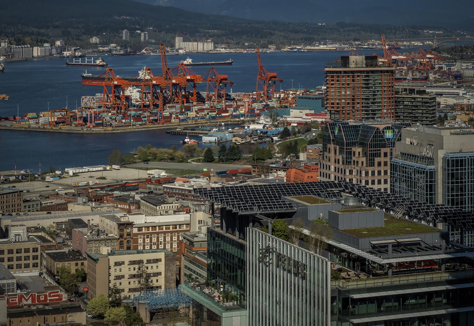 Aerial view of TELUS Garden in Vancouver with the Port of Vancouver and Gastown in the background, showcasing green roofs and sustainable architecture.