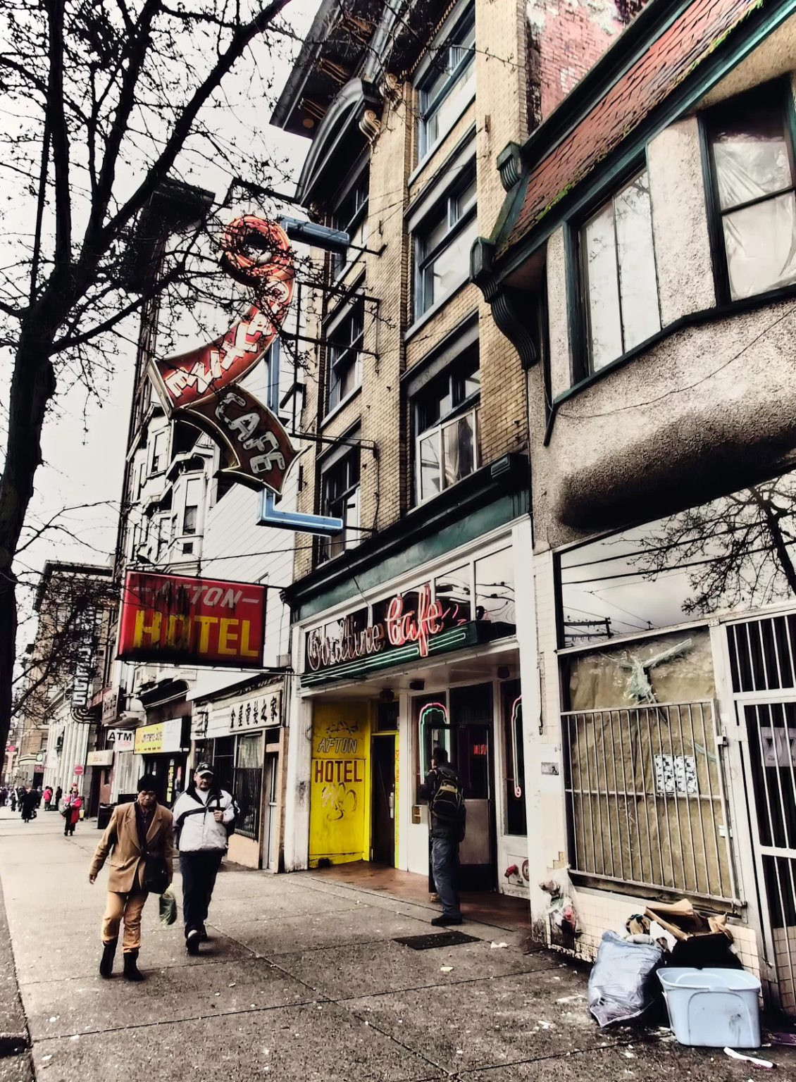 Afton Hotel on East Hastings Street, Vancouver, featuring Edwardian Italian Renaissance Revival architecture and the iconic Ovaltine Café with its neon sign.