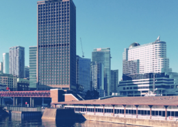 Granville Square in Vancouver, former home of the Vancouver Sun newspaper, with surrounding high-rise buildings reflecting in the waters of Burrard Inlet.