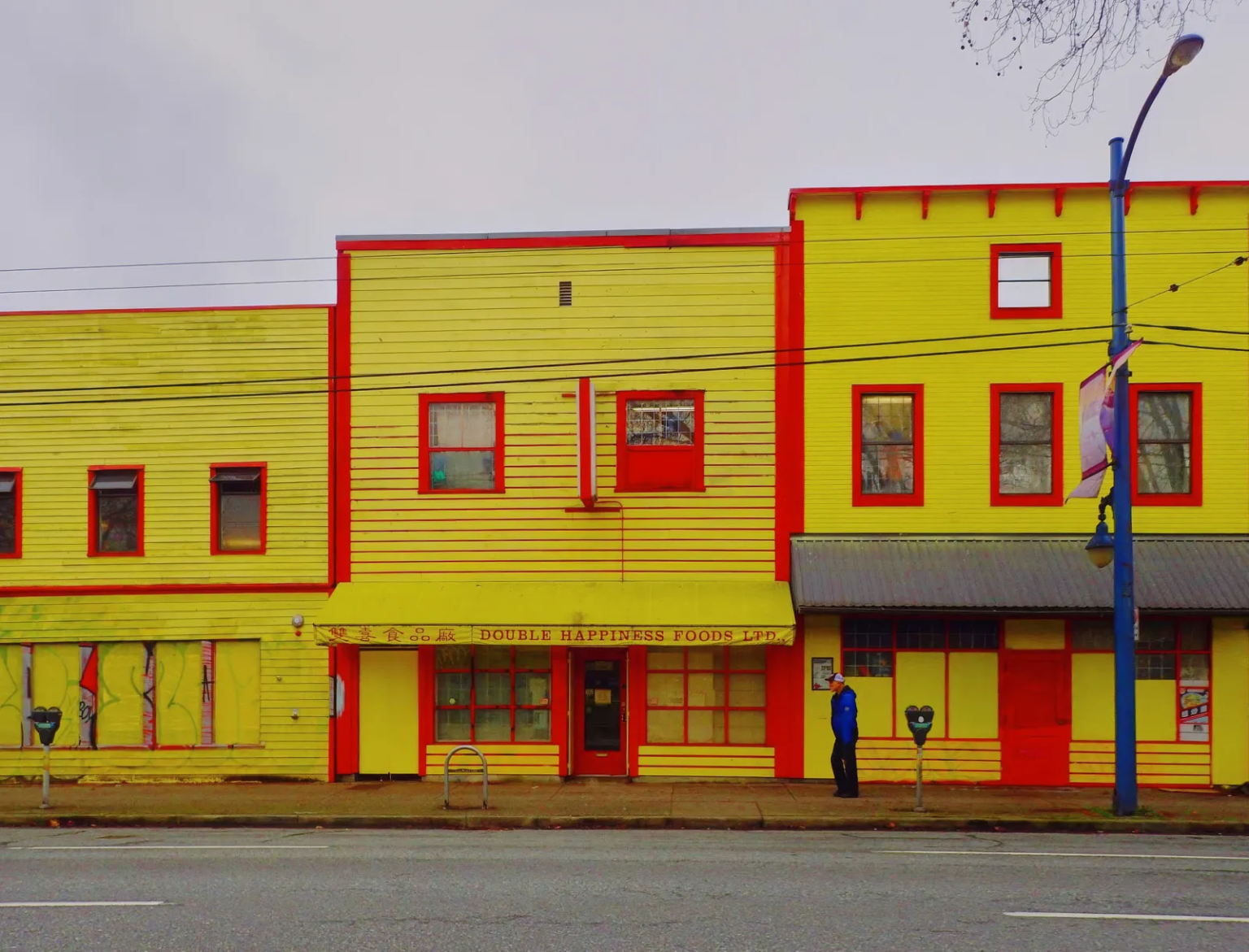 Bright yellow and red facade of Double Happiness Foods Ltd. in Vancouver's Downtown Eastside, a long-standing noodle workshop established in 1970.