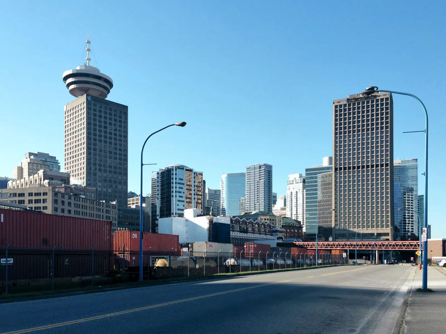 Vancouver's waterfront skyline, including the century-old Station building, modern skyscrapers, and shipping containers in the foreground.